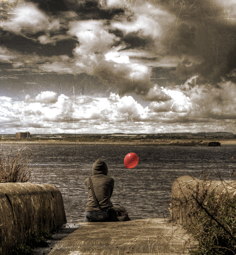A photo showing a girl sitting in front of a body of water called the South Gare in the North East of England and holding a little red balloon. Taken by JackMcIntyre on Deviant Art